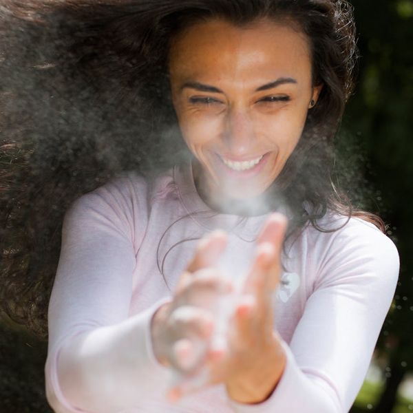 A woman in activewear feeling energetic and positive in a bright space.